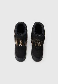 Melnas zābakus raksturo teksturēta zamšāda augšdaļa ar sakrātu elastīgu malu. Dekoratīvi frizūri gaišākā krāsā akcentē priekšpusi. Izturīga zole.