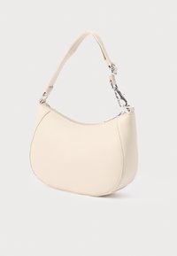 Bézs színű, ívelt formájú szintetikus kézitáska, texturált pánttal, ezüst színű fém kiegészítőkkel és felső cipzáras záródással.