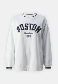 Sudadera blanca con la palabra "BOSTON" estampada en color marino, y "Massachusetts 1995" debajo. Cuello y puños acanalados con rayas marinas. Textura suave.