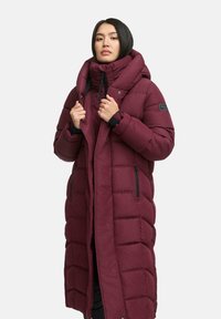 Burgundy puffer coat with a high collar, quilted texture, zippered pockets, and a fleece-lined interior for warmth.