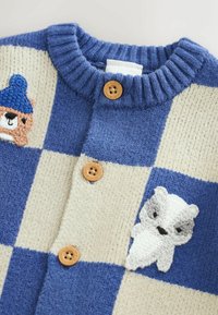 Knit cardigan featuring a blue and cream check pattern, wooden buttons, and embroidered bear and polar bear accents.
