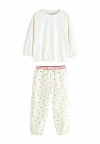 Kreemivärvi pikkade varrukatega särk elastsete mansettidega; ühte värvi kreemivärvi püksid roosa lillemustriga ja volangiga roosa vöökoht. Pehme kangast tekstuur.