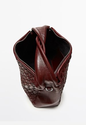 Bordowa skórzana torba o plecionej fakturze z gładkimi akcentami, wyposażona w zamknięcie na suwak od góry oraz pojedynczy pasek na ramię.