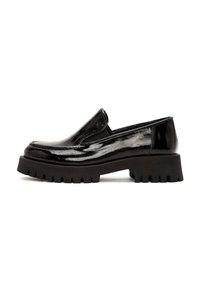 Scarpa slip-on in vernice nera con suola in gomma spessa e presa testurizzata. Presenta una punta arrotondata e dettagli elastici laterali.
