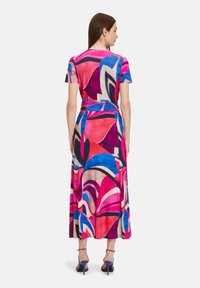 Maxikleid in leuchtendem Pink, Lila und blauen abstrakten Mustern. Kurze Ärmel, taillierter Schnitt, glattes Material und knöchellanges Design.