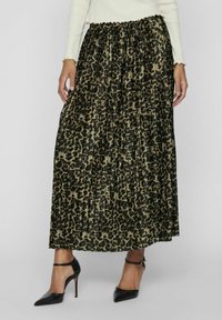 Maxi nederdel i en plisseret design med et sort og oliven leopardmønster. Parret med sorte højhælede sko.