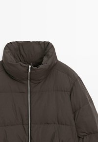 Ciemnobrązowa puchowa kurtka z wysokim kołnierzem, srebrnym zamkiem błyskawicznym i pikowaną fakturą z poziomym przeszyciem.