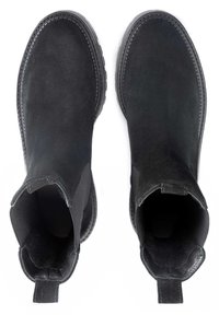 Bottines en suède noir avec des panneaux latéraux en élastique, bout rond, semelle texturée et une lanière à l'arrière pour un enfilage facile.