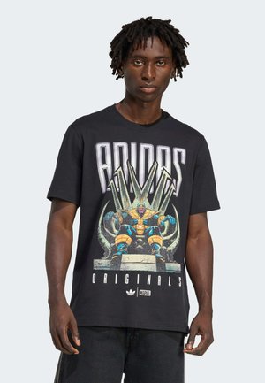 Black cotton t-shirt featuring a colorful graphic of Thanos on a throne, with bold "ADIDAS ORIGINALS" text above the image.