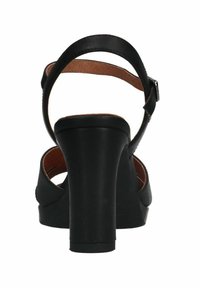 Zwarte sandalen met hakken, een dikke hak en een enkelbandje, met een glad leren bovenwerk en een bruine binnenzool. Open teen ontwerp.