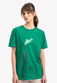 Groene katoenen t-shirt met een artistieke print van een figuur die een stok met rook vasthoudt, korte mouwen, ronde hals en een relaxed fit.