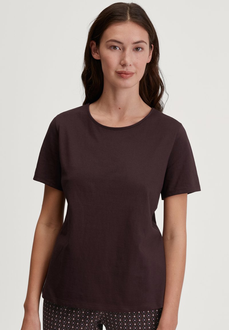 Donkerbruine katoenen t-shirt met korte mouwen, ronde halslijn en een relaxte pasvorm. De textuur is soepel, met een eenvoudige, effen kleur.