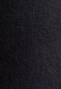 Czarna dzianina o gładkiej strukturze, z lekłym połyskiem i subtelnymi różnicami w grubości, prezentująca jednolity, solidny kolor.