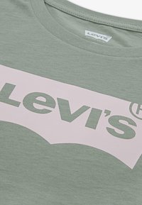 Grønn bomull t-skjorte med en stor rosa Levi's-logo i en kontrasterende design. Klassisk rund hals og glatt tekstur.