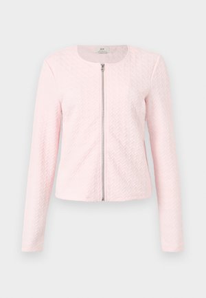 Veste matelassée rose clair à manches longues avec une fermeture éclair argentée à l'avant et un col rond, présentée sur un fond uni.