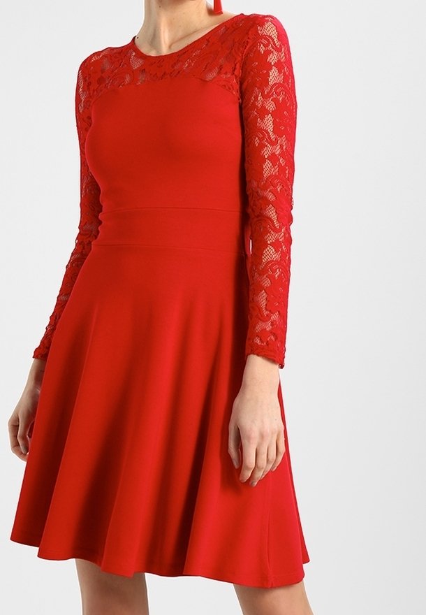 Robe rouge mi-longue avec manches longues en dentelle et détail en dentelle sur le haut de la poitrine, taille cintrée et jupe évasée.
