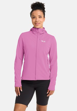 Leichte rosa Reißverschlussjacke mit Kapuze, strukturiertem Stoff, figurbetontem Schnitt und reflektierendem Logo, kombiniert mit schwarzen Radshorts.