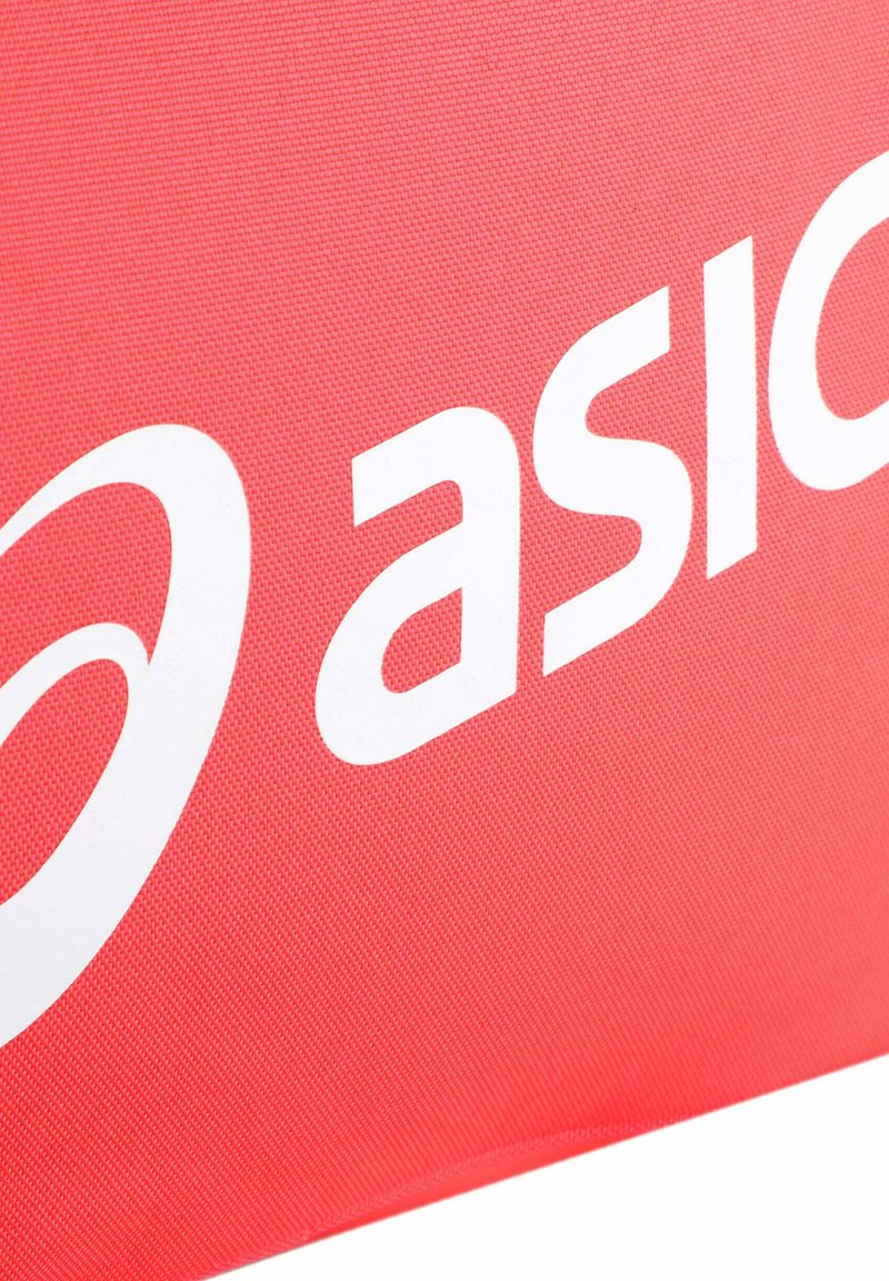 Gros plan d'un tissu rouge présentant un logo ASICS blanc partiel avec un design en spirale stylisé et des lettres en gras sur une surface texturée.