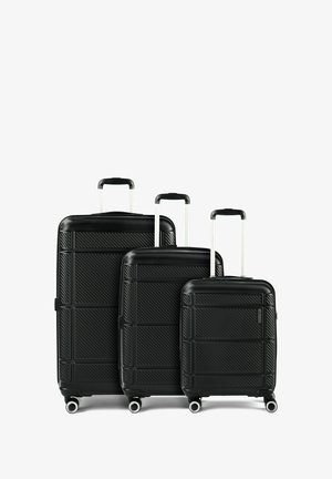 Drei schwarze Hartschalenkoffer in unterschiedlichen Größen mit ausziehbaren Griffen und vier Rollen, nebeneinander auf weißem Hintergrund angeordnet.