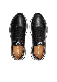 Zwarte leren sneakers met ronde neus, witte zoolrand en zwarte veters; heeft een tan binnenzool met logo van het merk en contrasterende veters.