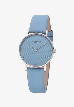 Montre bleu clair avec un cadran rond texturé et un bracelet en métal argenté. Le bracelet est en cuir lisse, arborant un design minimaliste.