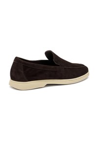 Scarpa slip-on in suede marrone con profilo basso, suola in gomma beige e dettagli cuciti lungo i bordi. Nessun hardware o accento visibile.
