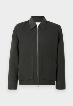 Chaqueta de mezcla de lana en verde oscuro con cuello tipo solapa, cremallera frontal y dos grandes bolsillos de parche. Diseño simple con textura suave.