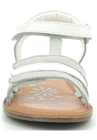 Sandale en cuir blanc avec trois lanières métalliques argentées et une semelle intérieure en tan à motif floral. Semelle plate et sangle de cheville ajustable.