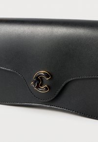 Schwarze Lederbrieftasche mit glatter Textur, die ein geschwungenes Design und einen auffälligen goldfarbenen C-förmigen Verschluss aufweist.