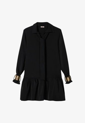 Zwarte jurk met kraag, lange mouwen en strikdetail. Heeft een geplooide zoom en gouden accenten bij de mouwboorden. Soepele stoftextuur.