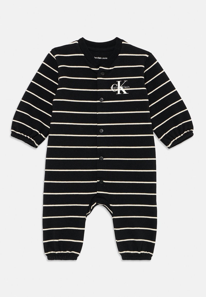 Μαύρη και λευκή ριγέ βαμβακερή φόρμα με μακριά μανίκια, κουμπιά σνάπ κατά μήκος του μπροστινού μέρους και ελαστικούς καρπούς. Λογότυπο Calvin Klein στο στήθος.