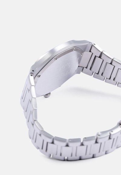 Silver metal watch with a shiny, smooth bracelet, rectangular case, and a simple metallic texture on the back. Visible clasp details.