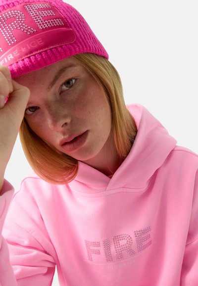 Rosa Kapuzenpullover mit "FIRE" in Strass; kombiniert mit einer gestrickten rosa Mütze mit einem Logo-Patch. Glatter Stoff und enganliegende Passform.