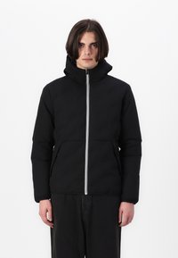 Sort hættetrøje med lynlås foran, der har en hvid lynlåsdetalje, to frontlommer og en polstret overflade for varme.