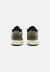 Gröna lädersneakers med svarta accenter och en strukturerad sula. Vingad logotyp på hälen, med en låg skärning och vadderad krage.