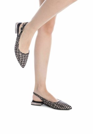 Zapato slingback de punta afilada con textura trenzada en negro y beige, tacón bajo y tira ajustable en el tobillo.