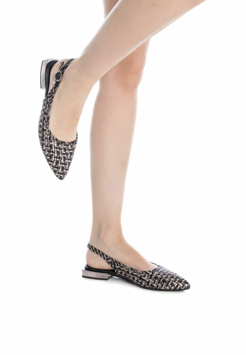 Zapato slingback de punta afilada con textura trenzada en negro y beige, tacón bajo y tira ajustable en el tobillo.
