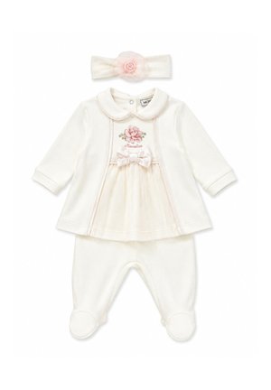 Crèmekleurige baby-outfit met lange mouwen, bloemenprint, strik op de borst, bijpassende broek met voetjes en hoofdband met roze bloemversiering.