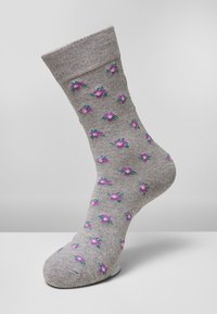 Grå strumpor med ett blommönster i lila och grönt, med en ribbad textur och en förstärkt fåll för ökad komfort.