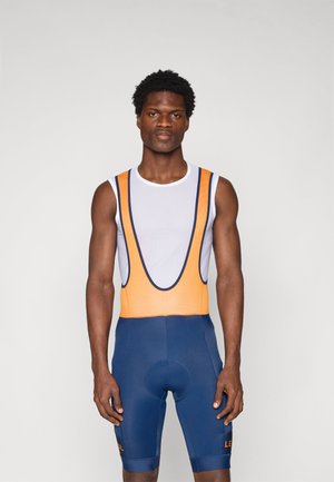 Conjunto de ciclismo para hombre con parte superior blanca de malla, acentos naranjas y pantalones cortos azules. Presenta un diseño ajustado y un asiento acolchado. Material suave y elástico.