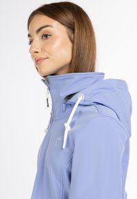 Világoskék, soft-shell dzseki magas gallérral, fehér húzókával és hímzett szív részlettel. Simára kidolgozott textúra és testhezálló kialakítás.