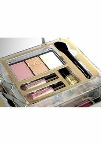 ZMIle Cosmetics meikkipaketti läpinäkyvässä kotelossa. Sisältää kolme puuterisävyä, kaksi huulikiiltoa, kynsilakkaa ja aplikaattoriharjan mustalla varrella.