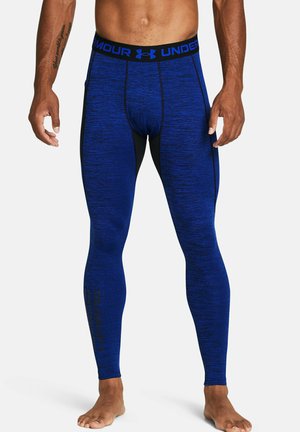 Blaue Sportleggings aus strukturiertem Material, mit einem schwarzen Bund mit Logo und seitlichen Akzenten. Enganliegendes Design für Aktivbekleidung.