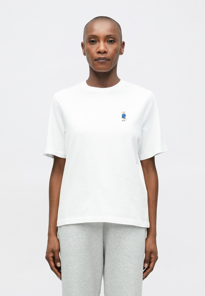 Λευκό βαμβακερό T-shirt με κοντά μανίκια και στρογγυλή λαιμ�όκοψη, που διαθέτει ένα μικρό刺αλιμένο σχέδιο στην αριστερή περιοχή του στήθους.
