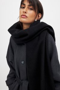 Abrigo de dos tonos, negro y gris, hecho de una tela suave, con un gran cuello doblado, cierre de botones y un cinturón atado en la cintura.