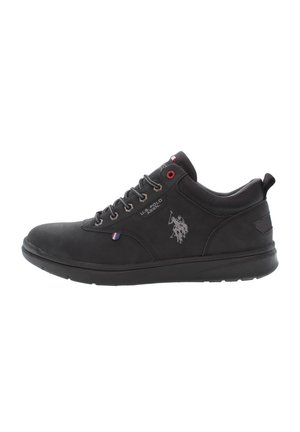 Zapatilla de cuero negra con puntera redonda, diseño de cordones, detalles plateados y logotipo en el lateral. Presenta ojales rojos y talón texturizado.