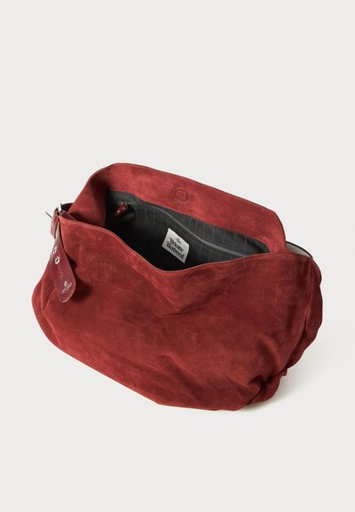 Sac à épaule en suède rouge doux avec une large ouverture, poche intérieure zippée, doublure noire et étiquette Vivienne Westwood.