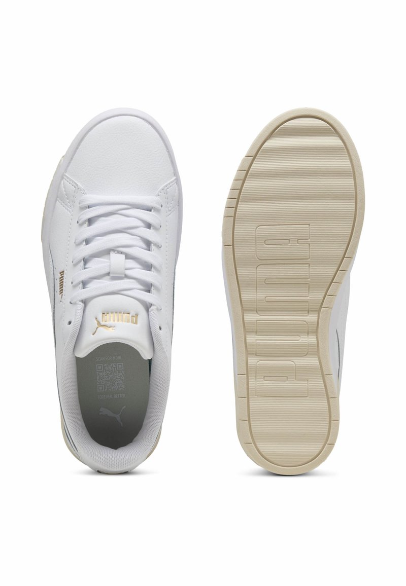 Baskets de sport blanches avec une tige en cuir lisse, bout rond, lacets blancs, et une semelle en caoutchouc beige texturée. Marquage doré sur le côté.