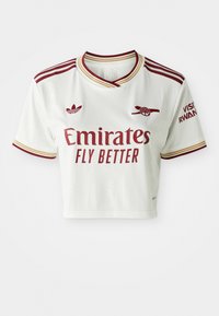 Bela športna majica s kratkimi rokavi z maroon Adidas črtami, logotipom Emirates Fly Better, grbom Arsenala in napisom Visit Rwanda na rokavu.