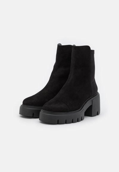 Botine negre din suede la gleznă, cu toc robust din cauciuc, având un finisaj neted și un design cu vârf rotund. Fără elemente metalice sau accente vizibile.